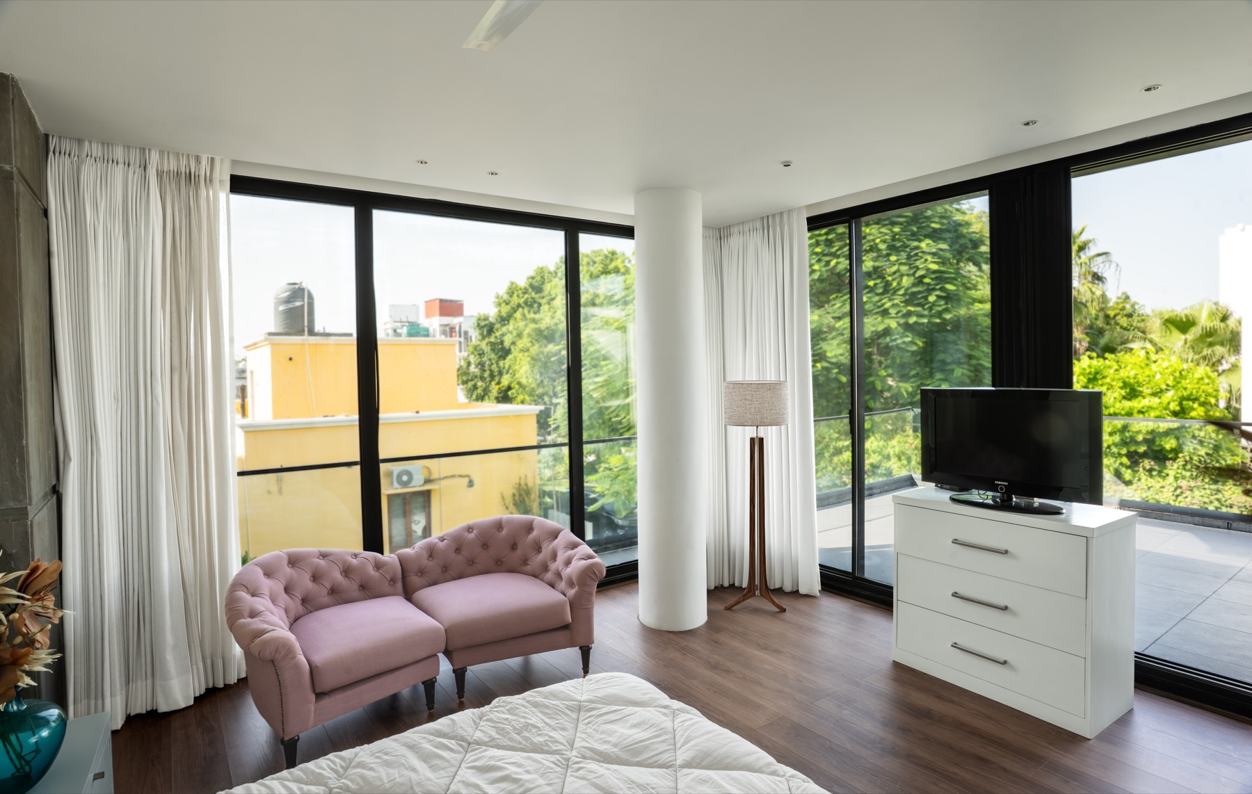 First-floor bedroom with rose chesterfield seat and wrap-around terrace views